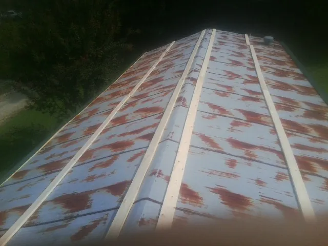 Rusted metal roof panels with new wood purlins before replacement — Storm Damage Roof Repair in Laotto by Roofing Brothers