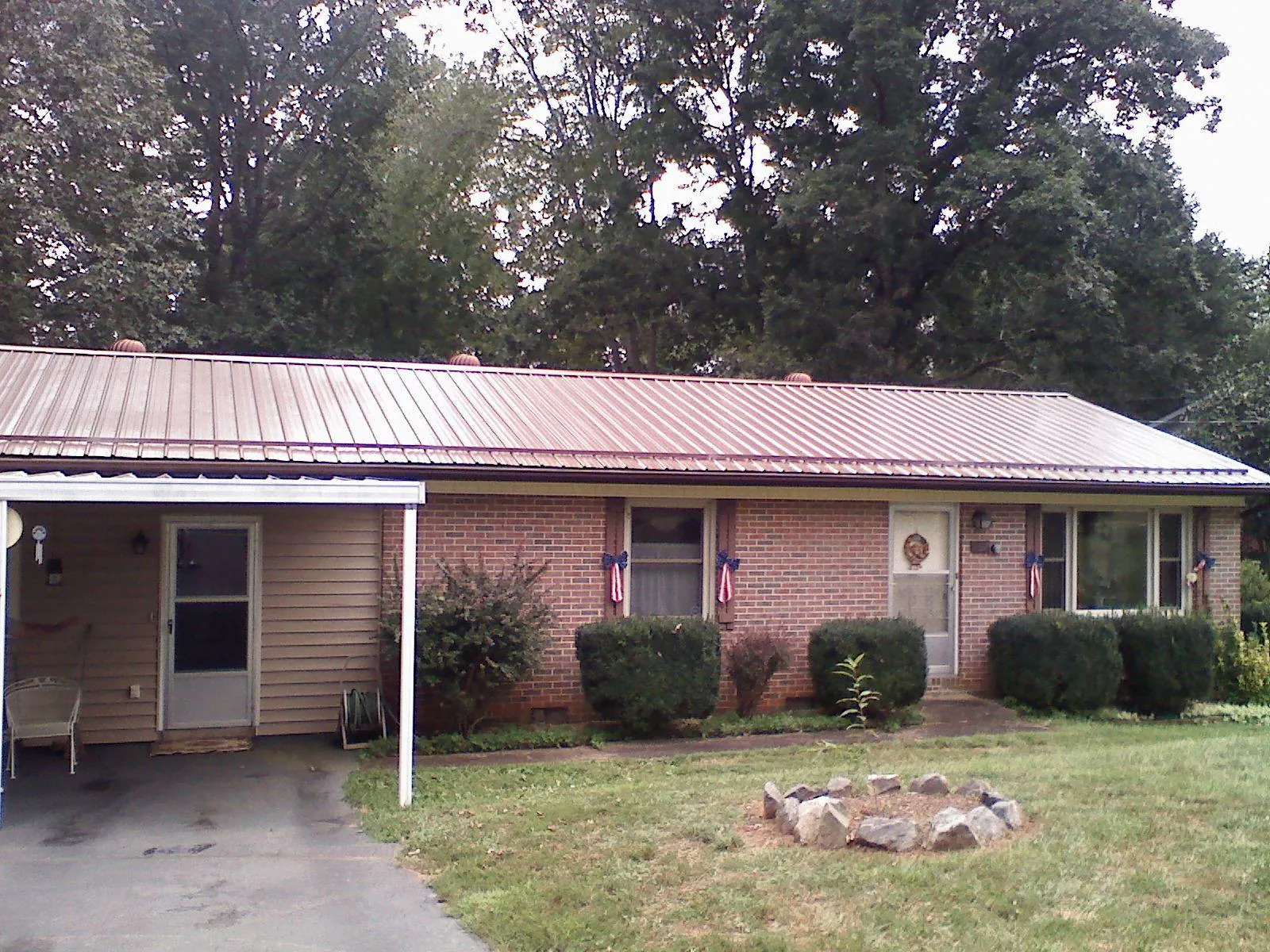 Bronze metal roof and carport on a brick ranch home — Roof Repair work by our crew in Laotto